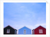 Beach huts in a row against sky by Assaf Frank